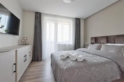 a bedroom with a large bed with two towels on it at Aušros apartamentai in Utena