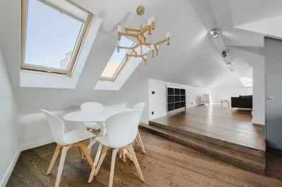 a white dining room with a white table and white chairs at Panoramic Loft - Lollo Luxury in Vilnius