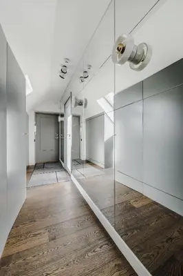 a hallway with a mirror and wood floor at Panoramic Loft - Lollo Luxury in Vilnius