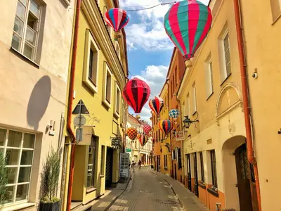 a row of red and green balloons flying over a street at Panoramic Loft - Lollo Luxury in Vilnius
