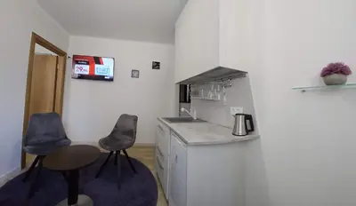 a kitchen with a counter and two stools in it at Kauno apartamentai 1 bed room in Kaunas