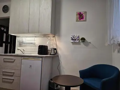 a small kitchen with a blue chair and a table at Kauno apartamentai 1 bed room in Kaunas
