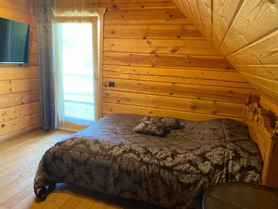 a bedroom with a bed in a log cabin at Pas sesutes sodyba in Pamarnakai