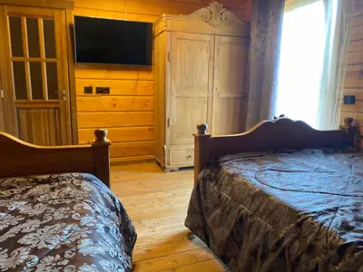 a bedroom with a bed and a dresser with a television at Pas sesutes sodyba in Pamarnakai