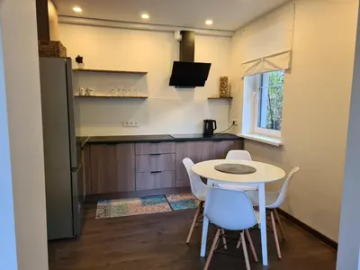 a small kitchen with a table and chairs in a room at GREEN HOUSE in Anykščiai