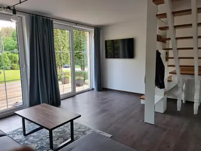 a living room with a table and a large window at GREEN HOUSE in Anykščiai