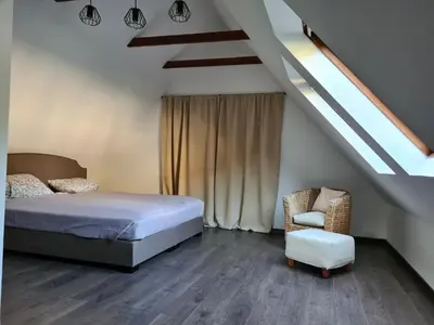 a bedroom with a bed and a chair at GREEN HOUSE in Anykščiai