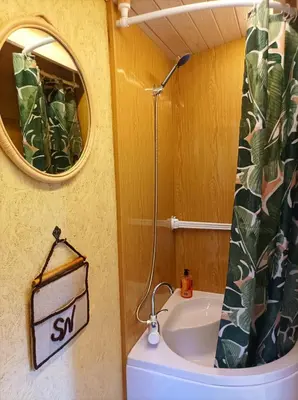a small bathroom with a sink and a mirror at Reed Cottage in Dzenkuniskes