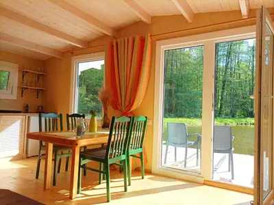 a dining room with a table and chairs and a window at Reed Cottage in Dzenkuniskes