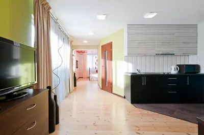 a kitchen with a television and a kitchen with a floor at Abariaus Apartamentai in Druskininkai