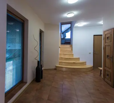 a hallway with wooden stairs and a stair case at Abariaus Apartamentai in Druskininkai