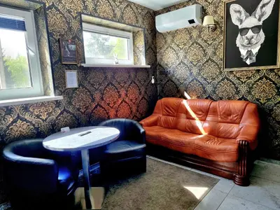 a living room with a leather couch and a table at Park apartments in Rokiškis