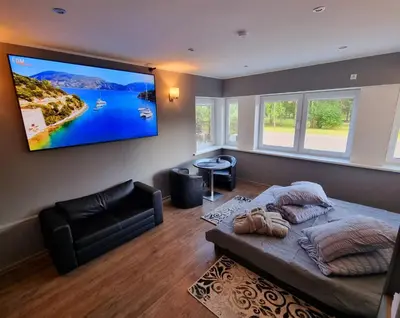a bedroom with a large flat screen tv on the wall at Park apartments in Rokiškis