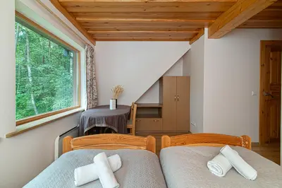 two beds in a room with a window at Villa Green in Molėtai