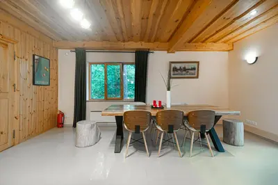 a dining room with a wooden table and chairs at Villa Green in Molėtai