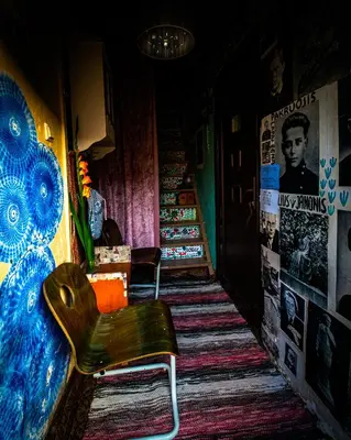 a hallway with a chair in a room with posters at Kabina in Pakruojis