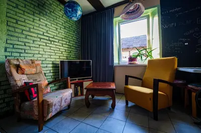 a living room with a chair and a tv at Kabina in Pakruojis