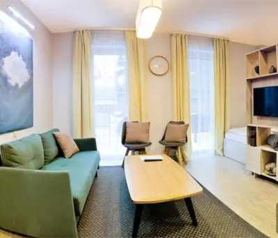 a living room with a couch and a table at HaPPy Inn Ugnė, The studio is in the heart of the old town, self-check-in, car-parking in Vilnius