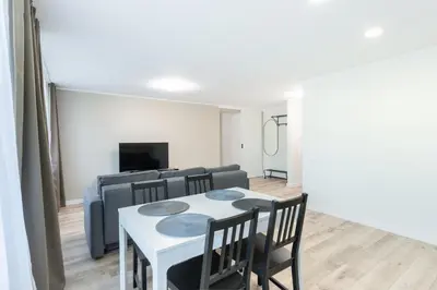 a living room with a table and chairs and a couch at Stiklo Apartamentai in Radviliškis