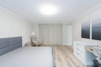 a white bedroom with a sink and a desk at Stiklo Apartamentai in Radviliškis
