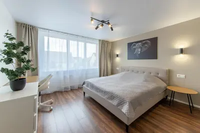 a bedroom with a bed and a large window at Stiklo Apartamentai in Radviliškis