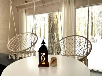 a table with two chairs and a candle on it at Miško sielos namelis su pirtele in Aukštelkė