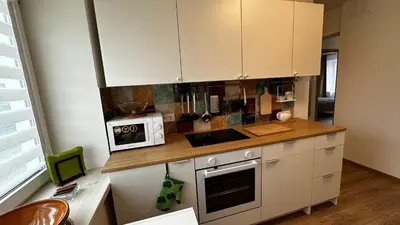 a kitchen with white cabinets and a microwave on a counter at Japandi apartamentai in Kaunas