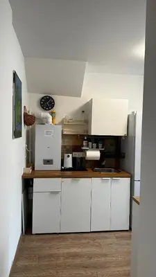 a kitchen with white cabinets and white appliances at Japandi apartamentai in Kaunas
