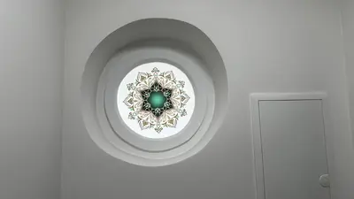 a room with a white wall with a green ornament at Japandi apartamentai in Kaunas