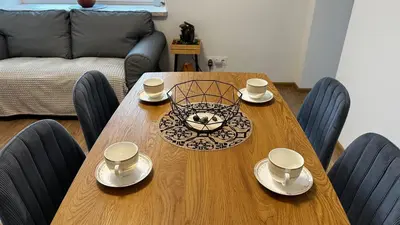 a wooden table with cups and saucers on it at Japandi apartamentai in Kaunas
