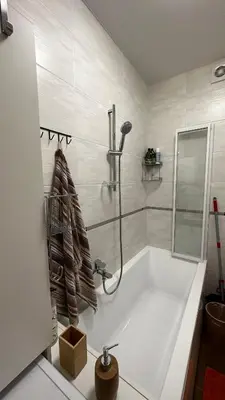 a white bathroom with a tub and a shower at Japandi apartamentai in Kaunas