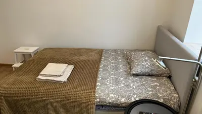 a small bedroom with a bed with a blanket at Japandi apartamentai in Kaunas