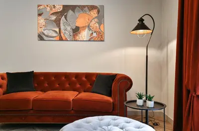 a living room with a brown couch and a lamp at cohost I Nicely Designed NEW Apt w-Garage Parking & Self Check-in in Vilnius
