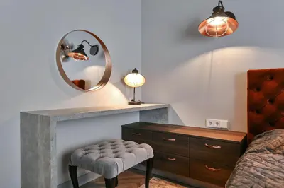 a bedroom with a mirror and a stool and a dresser at cohost I Nicely Designed NEW Apt w-Garage Parking & Self Check-in in Vilnius