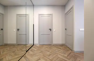 an empty room with two doors and wooden floors at cohost I Nicely Designed NEW Apt w-Garage Parking & Self Check-in in Vilnius