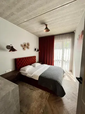 a bedroom with a large bed with a red headboard at cohost I Nicely Designed NEW Apt w-Garage Parking & Self Check-in in Vilnius
