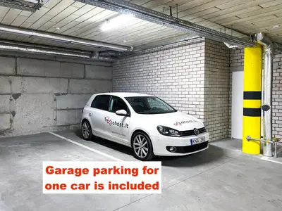 a white car parked in a parking garage at cohost I Nicely Designed NEW Apt w-Garage Parking & Self Check-in in Vilnius