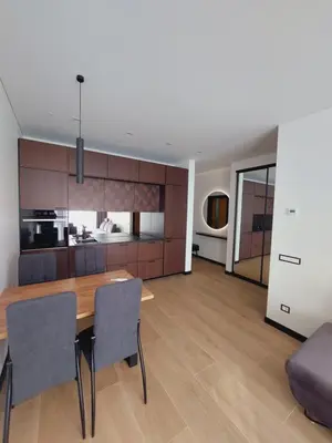 a kitchen and dining room with a wooden table and chairs at Birštono Perlas apartamentai in Birštonas