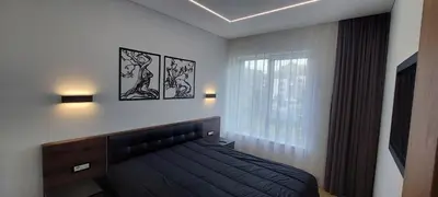 a bedroom with a black bed and a window at Birštono Perlas apartamentai in Birštonas