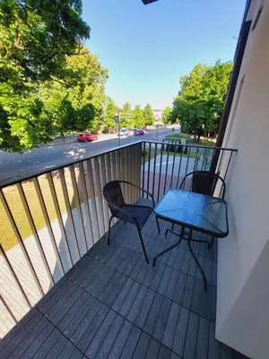 a balcony with two chairs and a table on it at Birštono Perlas apartamentai in Birštonas