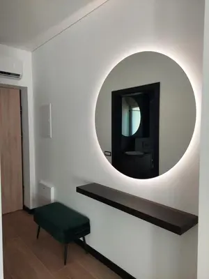 a bathroom with a mirror and a green stool at Birštono Perlas apartamentai in Birštonas