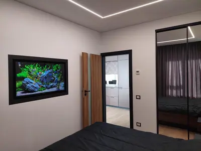a bedroom with a fish tank on the wall at Birštono Perlas apartamentai in Birštonas