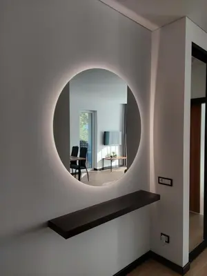 a round mirror on the wall of a living room at Birštono Perlas apartamentai in Birštonas