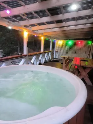 a large bath tub in a room with a table at Sodyba Valdo kubilas in Trakai