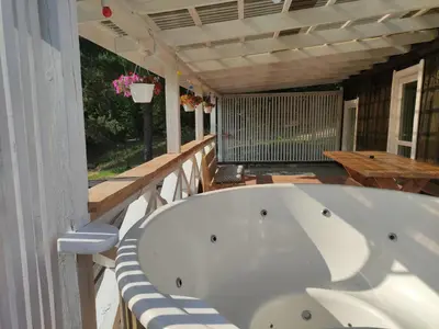 a white bath tub sitting on a porch at Sodyba Valdo kubilas in Trakai