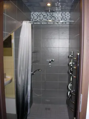 a shower with a shower curtain in a bathroom at Studio in Kaunas City in Kaunas