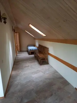a attic room with two chairs and a bed at My Forest Villa in Vilnius