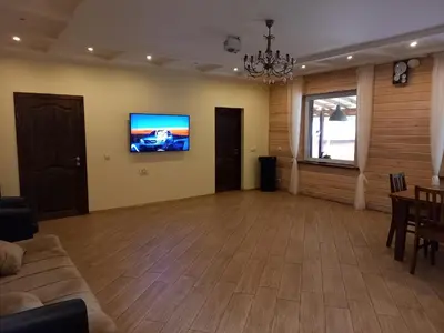 a living room with a couch and a tv on a wall at My Forest Villa in Vilnius