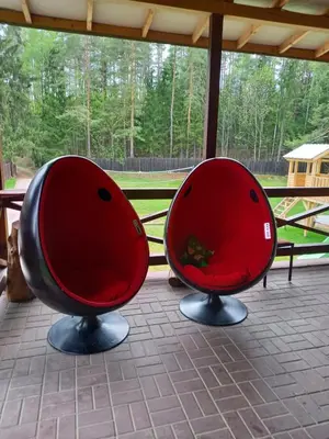 two red chairs sitting on a porch at My Forest Villa in Vilnius