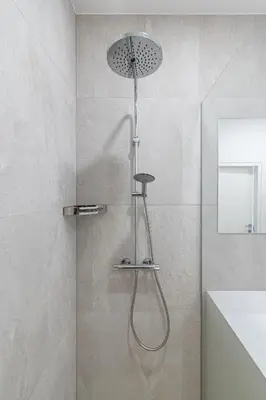 a shower with a shower head in a bathroom at Spaciuos 1 BD Apt by Domvia in Kaunas